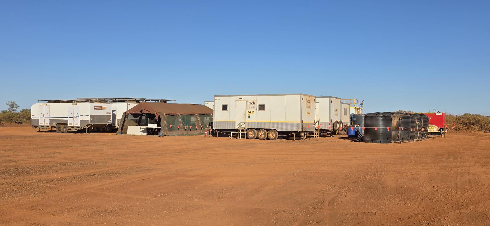A mobile accommodation caravan and tent set up in the outback